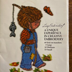 May include: A transfer pattern for loop embroidery featuring a boy with brown hair and blue overalls holding a fishing pole and a bucket. The pattern includes 68 iron-on transfers, 5 large, 10 medium, and 53 small.