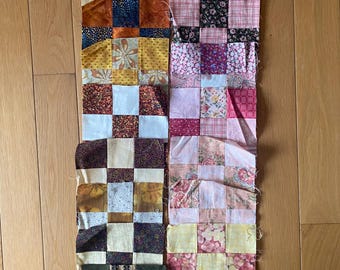 Può includere: Una collezione di 10 blocchi di patchwork per quilt, ognuno con un motivo diverso. I blocchi sono realizzati con vari tessuti in tonalità di marrone, rosa, giallo, bianco e blu. I blocchi sono disposti su due file, con cinque blocchi in ogni fila.