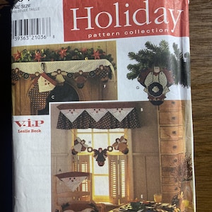 May include: A Simplicity Holiday pattern collection envelope featuring sewing instructions for fabric angel ornaments, a garland, a window valance, and table linens. The cover displays various finished textile projects in brown, cream, and red tones.