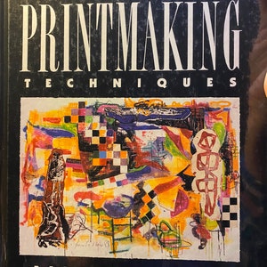May include: A book titled "Basic Printmaking Techniques" by Bernard Toale. The cover features an abstract painting with vibrant colors, including yellow, red, blue, green, and black. The painting includes geometric shapes and a checkered pattern.
