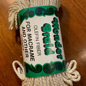 May include: A roll of white and gold Wonder Braid olefin fiber cord for macrame and other crafts.