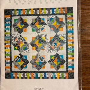 May include: A quilting pattern for a quilt called "Dotsville" measuring 67 inches by 67 inches. The quilt features a black, white, and colorful geometric design with a variety of patterns. The pattern is from "Quilting Discoveries" by Susan Mayer.