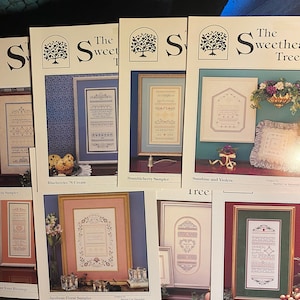 May include: A collection of cross-stitch sampler patterns. Each pattern features framed designs with floral and geometric motifs. Titles include "Blueberries 'N Cream", "Brambleberry Sampler", and "Sunshine and Violets". The Sweetheart Tree logo is visible on each pattern.