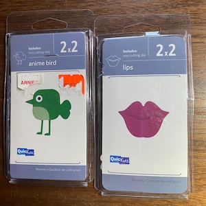 Puede incluir: Dos paquetes de plantillas de troquelado para manualidades. El primer paquete incluye dos troqueles para cortar un pájaro de anime. El segundo paquete incluye un troquel para cortar labios. Ambos paquetes están etiquetados con "2x2" y "QuicKutz".