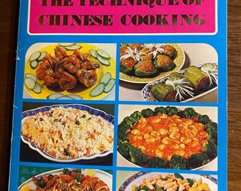 May include: A blue and white cookbook with the title "The Technique of Chinese Cooking" in gold lettering. The cover features four colourful photos of Chinese dishes, including shrimp, stuffed peppers, fried rice, and chicken.