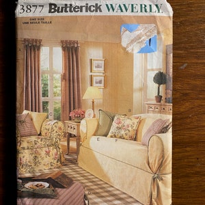 May include: A Butterick Waverly 3877 sewing pattern envelope featuring illustrations of a sofa, armchair, and various throw pillows. The cover displays furniture with floral and plaid fabric covers, including a cream sofa and a floral armchair.