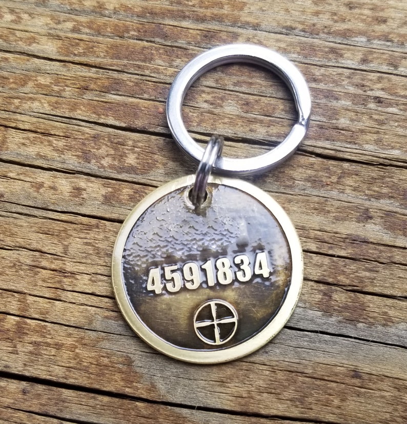 May include: A brass key chain with a round tag featuring the number 4591834 and a cross symbol.