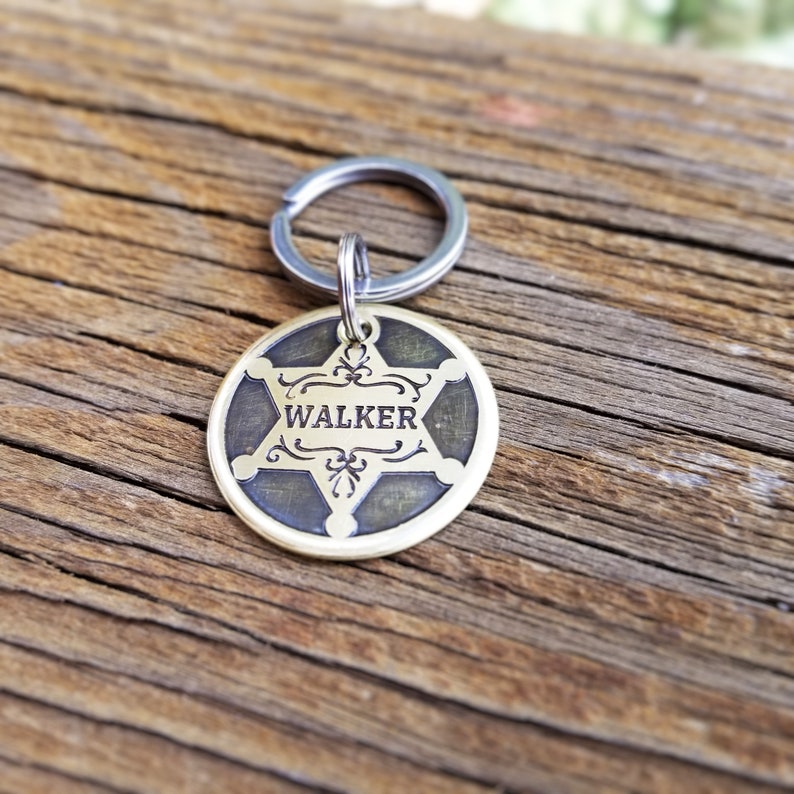 May include: A brass key chain with a sheriff's star design and the name "WALKER" engraved on it.