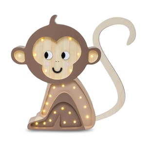 May include: A wooden monkey night light with a brown body and a light brown tail. The monkey has a smiling face with black eyes and a light brown nose. The night light has warm white LED lights that illuminate the monkey's body.
