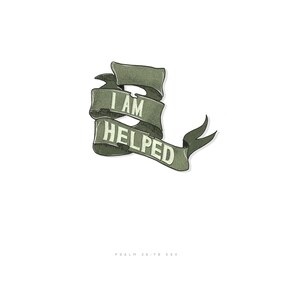 May include: Green ribbon with the text "I AM HELPED" in white lettering. The ribbon is curled and has a shadow. The text "PSALM 28:7B ESV" is below the ribbon.