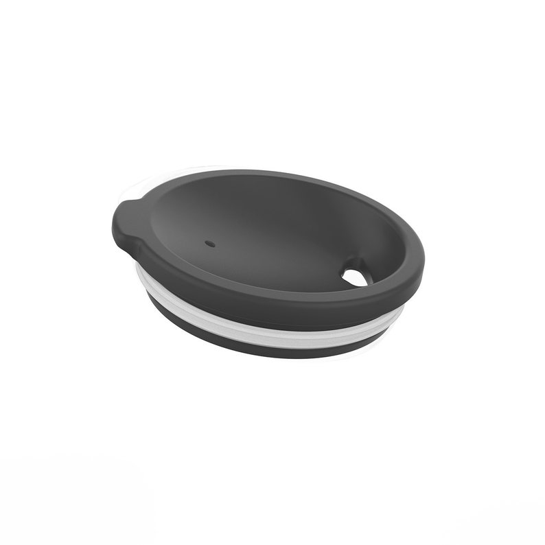 May include: A black silicone lid with a white silicone ring around the edge. The lid has a small hole in the center and a larger hole on the side.