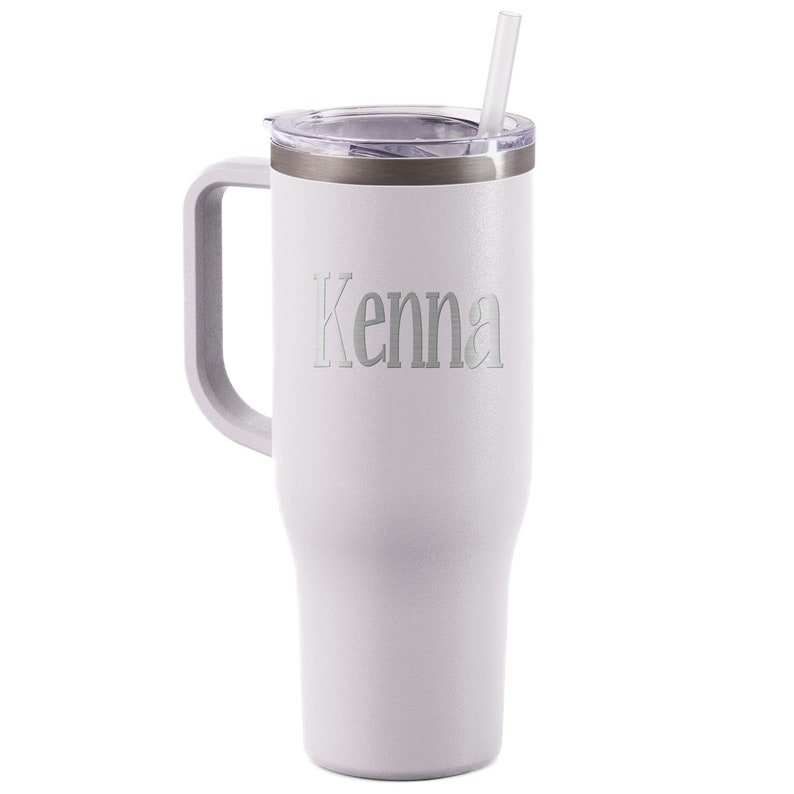 K&ouml;nnte beinhalten: Ein wei&szlig;er isolierter Becher mit Griff und transparentem Deckel. Der Becher hat einen silbernen Rand und einen durchsichtigen Strohhalm. Der Name "Kenna" ist auf der Vorderseite eingraviert. Der Becher ist etwa 25 cm hoch.