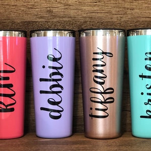 May include: Four personalized stainless steel tumblers with names "Kim", "Debbie", "Tiffany", and "Kristen" in black lettering. The tumblers are in various colors: coral, lavender, rose gold, and turquoise.