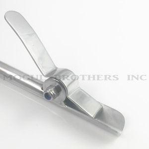 May include: A stainless steel pipe clamp with a lever release mechanism. The clamp is designed to secure pipes or tubing.