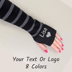 May include: Black and gray striped arm warmers with the name "Lisa" and a heart graphic. The text "Your Text Or Logo" and "8 Colors" are displayed at the bottom of the image.