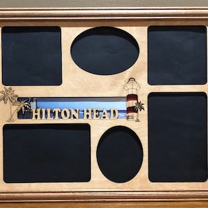 May include: A wooden picture frame with six cutouts for photos. The frame has a light wood finish and features a laser-cut design of a lighthouse, palm trees, and the words "HILTON HEAD".