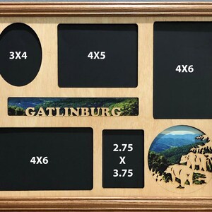 May include: A wooden picture frame with multiple openings for photos. The frame has a cutout of a mountain scene with the word "Gatlinburg" in the center. The frame has openings for photos of various sizes, including 3x4, 4x5, 4x6, and 2.75 x 3.75 inches.