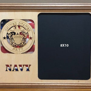 May include: A wooden picture frame with a navy blue background and a cutout of the United States Navy seal. The frame has a space for an 8x10 inch photo.