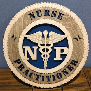 May include: A wooden sign with a rope border, featuring the text "NURSE PRACTITIONER" and the medical symbol with the letters "NP" inside. The background is blue.