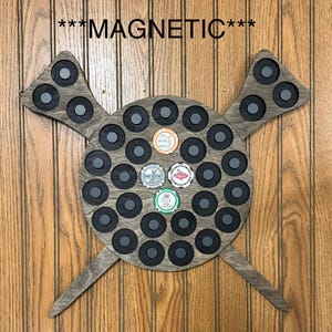 May include: A gray wooden magnetic poker chip holder with the word "MAGNETIC" above it. The holder has a circular center with multiple circular magnetic spaces and two wing-like extensions. Several poker chips are displayed.