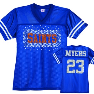 May include: Blue and white football jersey with rhinestones spelling "Saints" on the front and the number "23" with the name "Myers" on the back.