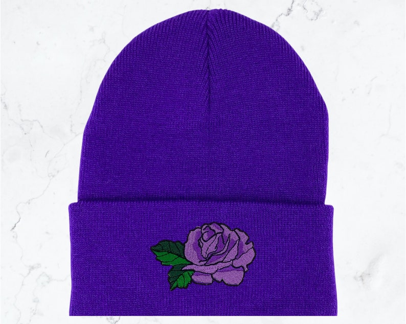 May include: Purple beanie with a purple rose embroidered on the front.