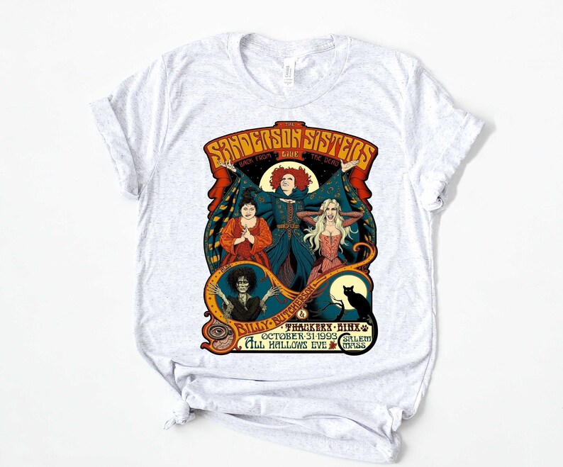 Pu&ograve; includere: Una maglietta bianca con una grafica in stile vintage delle sorelle Sanderson del film Hocus Pocus. La grafica presenta le tre sorelle nei loro costumi iconici, con il testo "The Sanderson Sisters" e "Back from the Dead" sopra di loro. Il testo "Billy Butcherson", "Thackeray Binx", "October 31, 1993", "Salem" e "All Hallows Eve Mass" &egrave; sotto le sorelle.