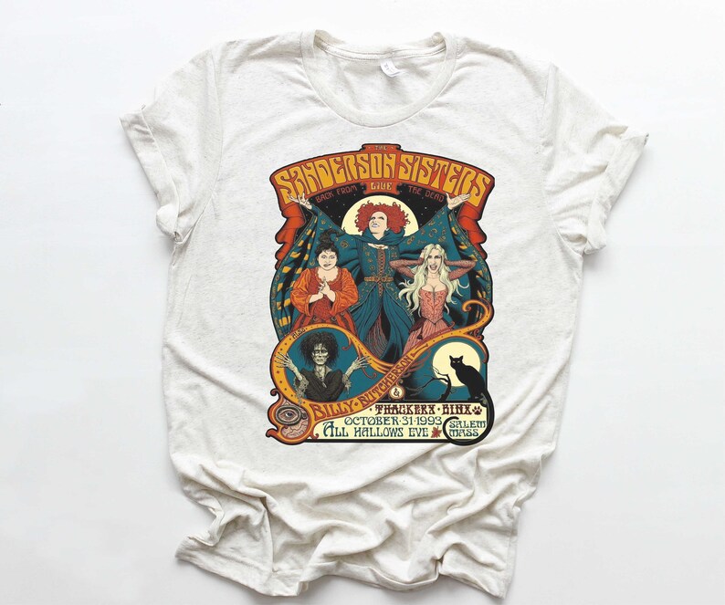 Pu&ograve; includere: Una maglietta bianca con una stampa grafica in stile vintage delle sorelle Sanderson del film Hocus Pocus. Il testo recita "The Sanderson Sisters Back From The Dead Live - Billy Butcherson - Thackery Binx - October 31, 1993 - Salem, Mass - All Hallows Eve."
