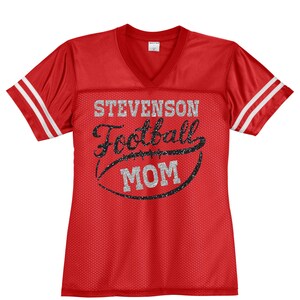 May include: Red and white football jersey with the text "Stevenson Football Mom" in silver glitter lettering.