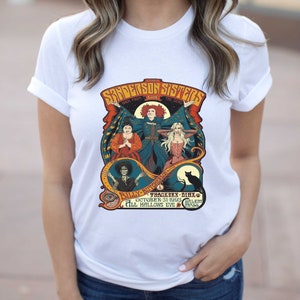 Pu&ograve; includere: Una maglietta bianca con una grafica in stile vintage delle sorelle Sanderson del film Hocus Pocus. La grafica presenta le tre sorelle, Winifred, Mary e Sarah, con il testo "The Sanderson Sisters Back From The Dead" e "Billy Butcherson's  Thackeray Binx October 31, 1993 Salem Mass All Hallows Eve."