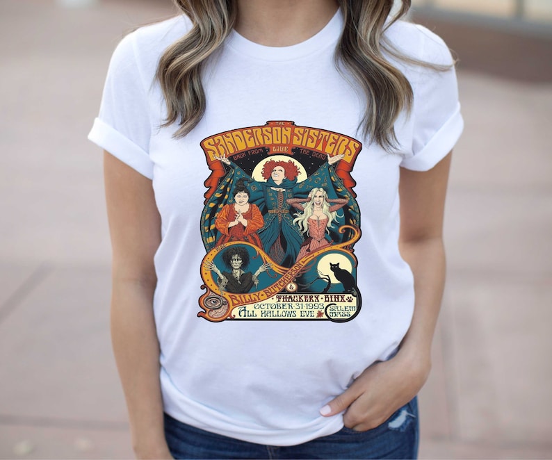 Pu&ograve; includere: Una maglietta bianca con una grafica in stile vintage delle sorelle Sanderson del film Hocus Pocus. La grafica presenta le tre sorelle, Winifred, Mary e Sarah, con il testo "The Sanderson Sisters Back From The Dead" e "Billy Butcherson's  Thackeray Binx October 31, 1993 Salem Mass All Hallows Eve."