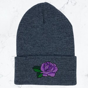 May include: Gray beanie with a purple rose embroidered on the front.