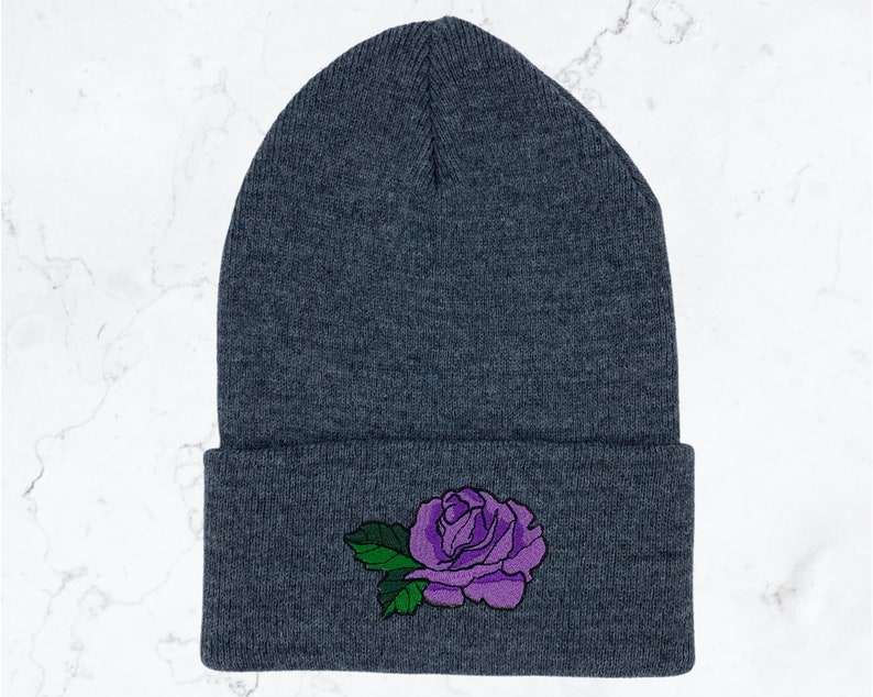 May include: Gray beanie with a purple rose embroidered on the front.
