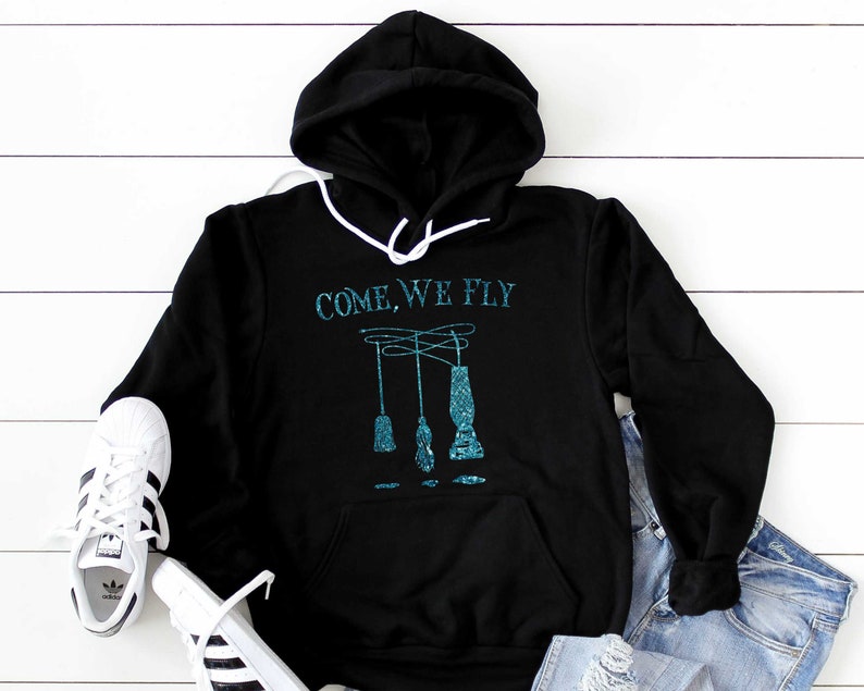 May include: Black hooded sweatshirt with a teal blue graphic that says "COME, WE FLY" and a design of three teal blue hanging lamps.