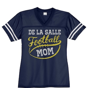 May include: Navy blue football jersey with white stripes on the sleeves. The jersey has gold glitter lettering that says "De La Salle Football Mom" with a gold glitter football graphic.