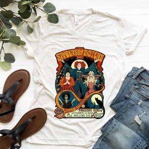Pu&ograve; includere: Una maglietta bianca con una grafica in stile vintage delle sorelle Sanderson del film Hocus Pocus. La grafica presenta le tre sorelle nei loro costumi iconici, con il testo "Sanderson Sisters" e "Back From The Dead" sopra di loro. Il testo "Billy Butcherson" e "Thackerx - Binx" &egrave; sotto le sorelle, insieme alla data "October 31, 1993" e alla localit&agrave; "Salem, Mass."