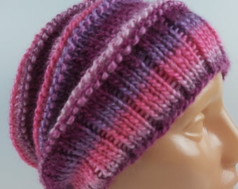 May include: A pink and purple knitted beanie hat with a textured pattern.