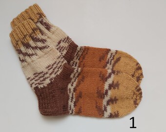 May include: A pair of brown, beige, and gold knitted socks with a geometric pattern. The socks are folded together and the toe of one sock is visible.