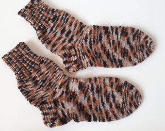May include: A pair of brown, black and white striped knitted socks.