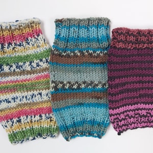 Peut inclure: Trois chauffe-jambes tricotés dans des motifs de couleurs différentes. Le premier est un motif rayé multicolore avec du rose, du jaune, du vert et du bleu. Le deuxième est un motif rayé bleu et marron. Le troisième est un motif rayé violet foncé et rose.