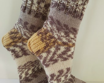 May include: A pair of brown, beige and gold knitted socks with a geometric pattern.