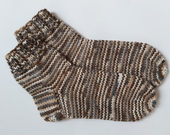 May include: A pair of brown, white and grey striped knitted socks. The socks are folded over and the toes are visible.