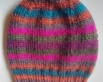 May include: A colourful striped knitted hat with a variety of colours including pink, orange, teal, purple, and grey.