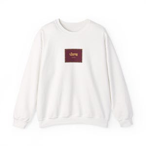 Könnte beinhalten: Ein weißes Sweatshirt mit Rundhalsausschnitt und einem mittigen rechteckigen Aufdruck. Das Motiv hat einen dunkelweinroten Hintergrund mit einem dekorativen Rand und dem Wort Punjab in gelber Gurmukhi-Schrift.