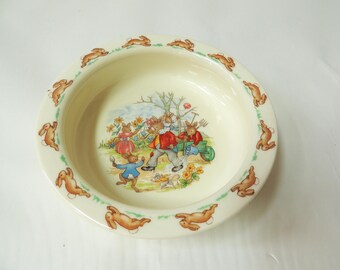 Vintage decoratieve kinderkom van Royal Doulton met konijntjesmotief, gemaakt van fijn porselein.