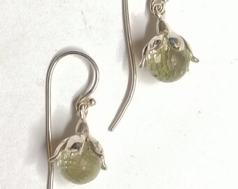May include: A pair of silver earrings with green gemstone flower accents.