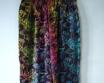 May include: Black trousers featuring a repeating pattern of rainbow-coloured mushrooms. The mushrooms are outlined in vibrant hues, creating a psychedelic effect. The trousers have an elasticated waistband.