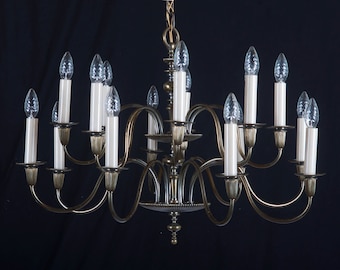 May include: A brass chandelier with 12 candle-style light bulbs. The chandelier has a traditional design with curved arms and a central decorative element.