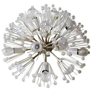 May include: A large, round, white and silver chandelier with multiple light bulbs and clear glass orbs. The chandelier is designed to resemble a dandelion.