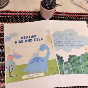 May include: A children's book titled "Bedtime Hide and Seek" with a blue dinosaur and a yellow dinosaur on the cover. The text reads "Bedtime hide and seek for all the kids who won't go to sleep. A sleepy story! You hide, I seek and when I find you, you better start counting sheep!"  The book is by Sunn Kat.